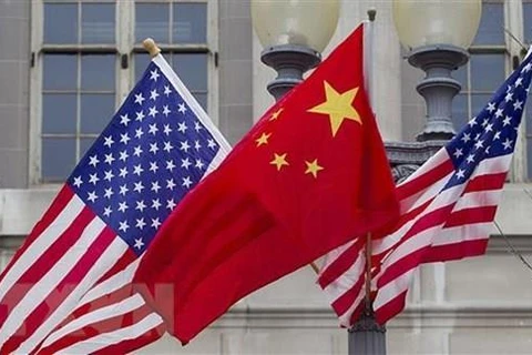 Quốc kỳ Trung Quốc (giữa) và quốc kỳ Mỹ. (Ảnh: Getty Images/TTXVN)