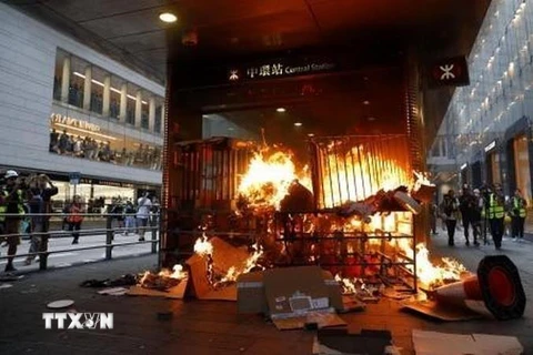Hình ảnh người biểu tình đốt phá tại lối vào một ga tàu điện ngầm ở Hong Kong. (Ảnh: Kyodo/TTXVN)