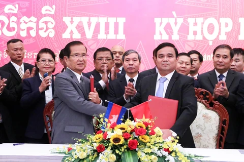 Thượng tướng Lê Chiêm, Thứ trưởng Bộ Quốc phòng (phải) và ông Sieng Lapresse (trái) trao Biên bản Kỳ họp lần thứ 18. (Ảnh: Xuân Khu/TTXVN)