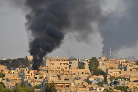 Khói bốc lên tại Ras al-Ain, miền Bắc Syria sau các cuộc tấn công của quân đội Thổ Nhĩ Kỳ nhằm vào lực lượng người Kurd. (Ảnh: AFP/TTXVN)