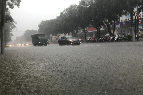 Nhiều tuyến đường ngập nước khiến phương tiện tham gia giao thông gặp nhiều khó khăn tại thành phố Vinh. (Ảnh: Bích Huệ/TTXVN)