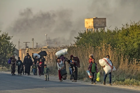 Người dân sơ tán tránh chiến sự ở thị trấn Ras al-Ain, tỉnh Hasakeh (Đông Bắc Syria). (Ảnh: AFP/TTXVN)