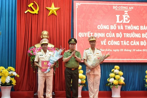 Thứ trưởng Bùi Văn Nam tặng hoa chúc mừng Đại tá Lê Tấn Tới và Đại tá Trần Phong. (Ảnh:TTXVN)