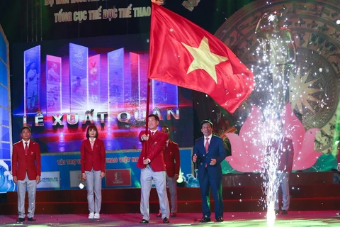 Ông Trần Đức Phấn, Phó Tổng cục trưởng Tổng cục Thể dục thể thao, Trưởng Đoàn thể thao Việt Nam tham dự SEA Games 30 phất cao lá quốc kỳ Việt Nam trong Lễ xuất quân. (Ảnh: Trọng Đạt/TTXVN)
