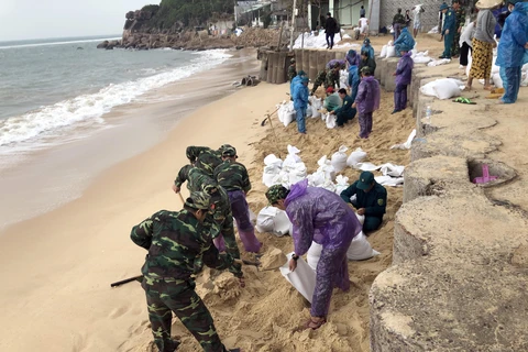 Lực lượng vũ trang tại tỉnh Bình Định xúc cát giúp người dân xã Nhơn Hải, TP Quy Nhơn gia cố nhà cửa chống bão số 6. (Ảnh: Nguyên Linh -TTXVN)