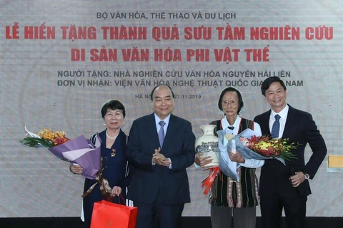 Thủ tướng Nguyễn Xuân Phúc tặng hoa Nhà nghiên cứu văn hoá Nguyễn Hải Liên. (Ảnh: Thống Nhất /TTXVN)