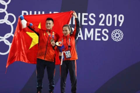 Lại Gia Thành (bên phải) và Vương Thị Huyền (cử tạ nữ) ăn mừng chiến thắng. (Ảnh: Hoàng Linh/TTXVN)