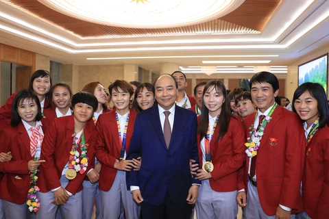 Thủ tướng Nguyễn Xuân Phúc chụp ảnh chung với các tuyển thủ bóng đá nữ quốc gia. (Ảnh: Thống Nhất/TTXVN)