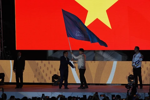 Bộ trưởng Bộ Văn hóa, Thể thao và Du lịch Việt Nam Nguyễn Ngọc Thiện (trái) đã nhận cờ đăng cai kỳ SEA Games 31 từ Chủ tịch Ủy ban Olympic Philippines Bambol Tolentino. (Ảnh: AFP/TTXVN)