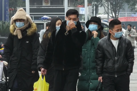 Hành khách đeo khẩu trang đề phòng lây nhiễm virus corona. (Ảnh: AFP/TTXVN)