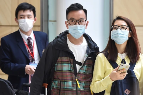 Hành khách đeo khẩu trang phòng dịch viêm phổi do virus corona. (Ảnh: AFP/TTXVN)