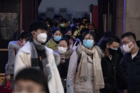 Người dân đeo khẩu trang để phòng tránh lây nhiễm virus corona tại nhà ga tàu hỏa ở Bắc Kinh, Trung Quốc. (Ảnh: AFP/TTXVN)