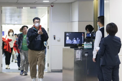 Nhân viên Trung tâm Kiểm soát dịch bệnh Đài Loan sử dụng máy quét để kiểm tra thân nhiệt các hành khách. (Ảnh: AFP/TTXVN)