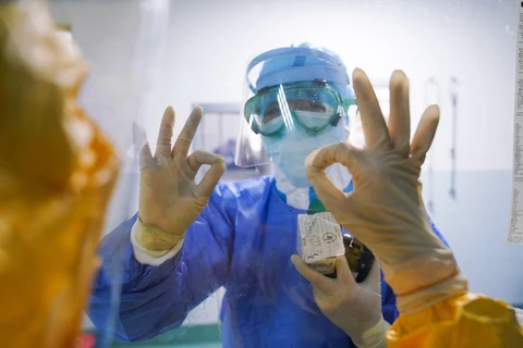 Các nhân viên y tế chào nhau qua ô cửa kính tại khu vực cách ly điều trị cho bệnh nhân nhiễm virus corona của bệnh viện ở Chương Châu, tỉnh Phúc Kiến, Trung Quốc, ngày 4/2. (Ảnh: THX/TTXVN)