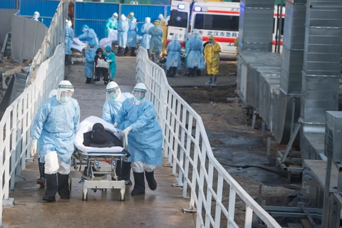 Nhân viên y tế chăm sóc bệnh nhân nhiễm virus corona tại khu vực cách ly của bệnh viện Hỏa Thần Sơn ở Vũ Hán, Trung Quốc, ngày 4/2. (Ảnh: THX/TTXVN)