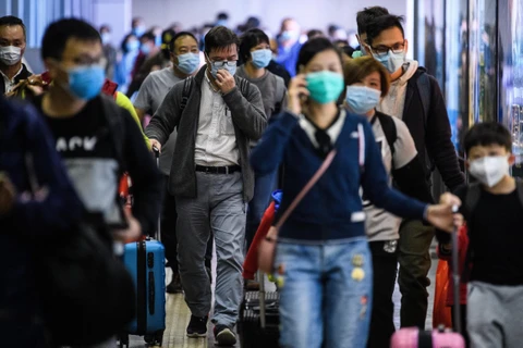Hành khách đeo khẩu trang đề phòng lây nhiễm virus corona chủng mới tại một nhà ga ở Hong Kong. (Ảnh: AFP/TTXVN)