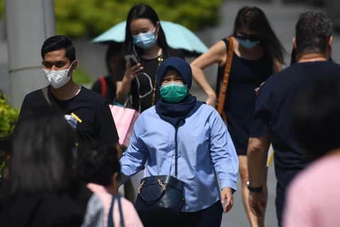 Người dân đeo khẩu trang để phòng tránh lây nhiễm virus corona chủng mới tại Singapore ngày 4/2. (Ảnh: AFP/ TTXVN)