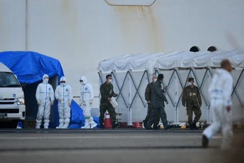 Nhân viên y tế làm nhiệm vụ gần du thuyền Diamond Princess bị cách ly tại cảng Yokohama, Nhật Bản ngày 13/2. (Ảnh: AFP/TTXVN)