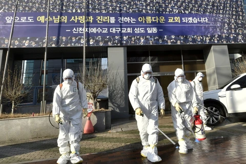 Nhân viên y tế phun thuốc khử chùng ngăn chặn sự lây lan của dịch bệnh COVID-19 tại Daegu, Hàn Quốc ngày 19/2. (Ảnh: AFP/TTXVN)