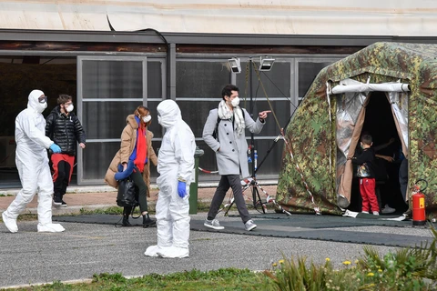 Nhân viên y tế Italy làm nhiệm vụ tại khu cách ly của một sân bay quân sự ở Pratica di Mare, phía Nam thủ đô Rome. (Ảnh: AFP/TTXVN)