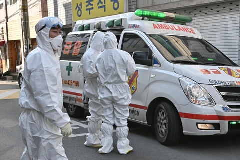 Nhân viên y tế Hàn Quốc làm nhiệm vụ tại một khu dân cư ở thành phố Daegu, nơi phát hiện các trường hợp có triệu trứng nhiễm virus SARS-CoV-2. (Ảnh: AFP/TTXVN)