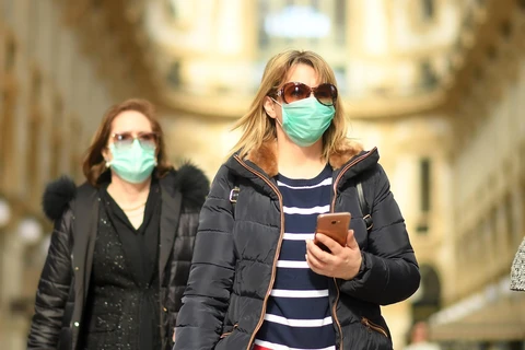 Người dân đeo khẩu trang để phòng tránh lây nhiễm COVID-19 tại Milan, Italy. (Ảnh: THX/TTXVN)