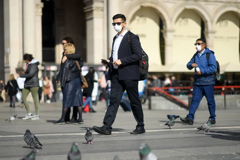 Người dân đeo khẩu trang để phòng tránh lây nhiễm COVID-19 tại Milan, Italy. (Ảnh: THX/TTXVN)