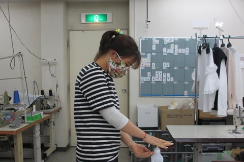 Thực tập sinh Việt Nam tại Công ty TNHH Mishow (Tokyo) sử dụng cồn để sát khuẩn trước khi vào làm việc. (Ảnh: Đào Thanh Tùng/TTXVN)