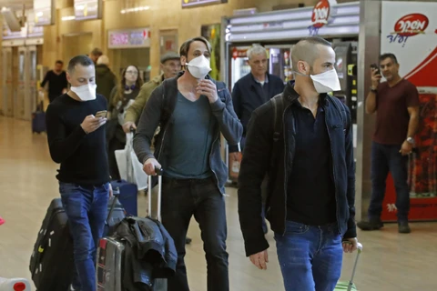 Hành khách đeo khẩu trang phòng dịch COVID-19 tại sân bay quốc tế Ben Gurion gần Tel Aviv, Israel. (Ảnh: AFP/TTXVN)