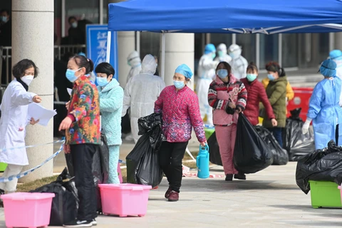 Bệnh nhân nhiễm COVID-19 xuất viện sau khi được chữa khỏi tại bệnh viện ở Vũ Hán, tỉnh Hồ Bắc, Trung Quốc. (Ảnh: THX/TTXVN)