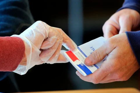 Người dân Pháp đeo găng tay phòng COVID-19 đi bỏ phiếu. (Nguồn: AP)