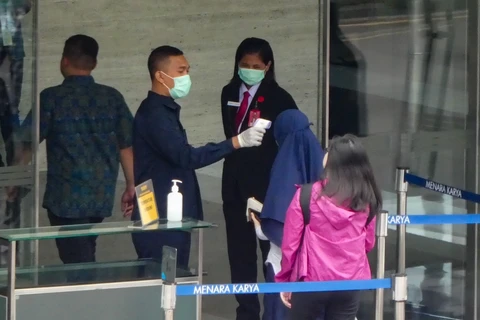 Đo thân nhiệt nhằm ngăn chặn lây nhiễm COVID-19 tại Jakarta, Indonesia, ngày 13/3. (Ảnh: AFP/TTXVN)