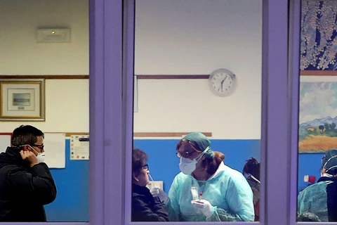 Các nhân viên y tế tiến hành xét nghiệm cho người dân tại Vò. (Nguồn: EPA)
