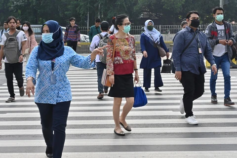Người dân đeo khẩu trang phòng lây nhiễm COVID-19 tại Jakarta, Indonesia. (Ảnh: AFP/TTXVN)