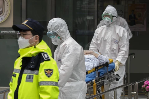 Nhân viên y tế chuyển bệnh nhân nhiễm COVID-19 tới bệnh viện tại Daegu, Hàn Quốc, ngày 19/3/2020. (Ảnh: THX/TTXVN)