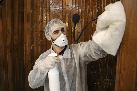 Công nhân phun thuốc khử trùng một nhà thờ nhằm ngăn dịch COVID-19 tại thành phố Hebron, Bờ Tây. (Ảnh: AFP/TTXVN)