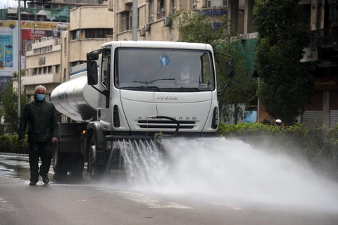 Phun khử trùng một đường phố ở thủ đô Damascus, Syria nhằm ngăn chặn sự lây lan của dịch COVID-19. (Ảnh: THX/TTXVN)
