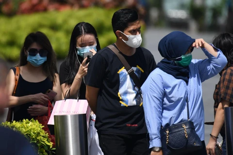 Người dân đeo khẩu trang phòng dịch COVID-2 tại Singapore. (Ảnh: AFP/TTXVN)