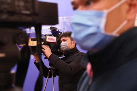 Phóng viên các cơ quan báo chí đeo khẩu trang tác nghiệp tại họp báo. (Ảnh: Lâm Khánh/TTXVN)