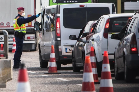 Cảnh sát Hungary kiểm tra thân nhiệt của tài xế tại khu vực cửa khẩu giữa Hungary-Áo, nhằm ngăn chặn sự lây lan của dịch COVID-19. (Ảnh: AFP/TTXVN)