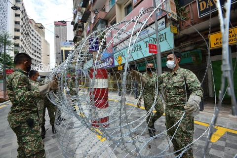 Binh sỹ Malaysia đặt rào chắn để thực hiện Mệnh lệnh Kiểm soát Di chuyển (MCO) tại Kuala Lumpur, Malaysia. (Ảnh: THX/TTXVN)