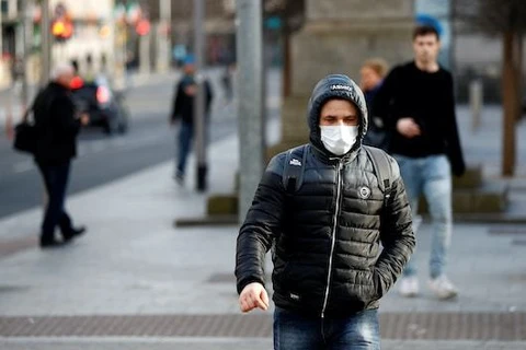 Một người dân Ireland đeo khẩu trang khi ra ngoài đường. (Nguồn: Reuters)