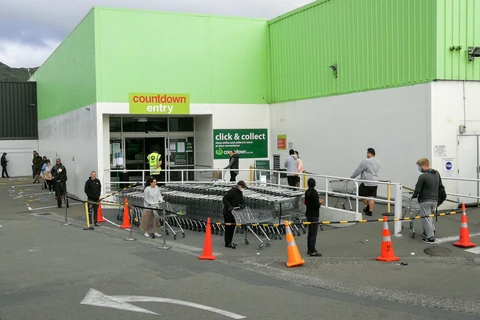 Người dân thực hiện giãn cách xã hội để phòng tránh lây nhiễm COVID-19 khi xếp hàng vào siêu thị tại Wellington, New Zealand. (Ảnh: THX/TTXVN)