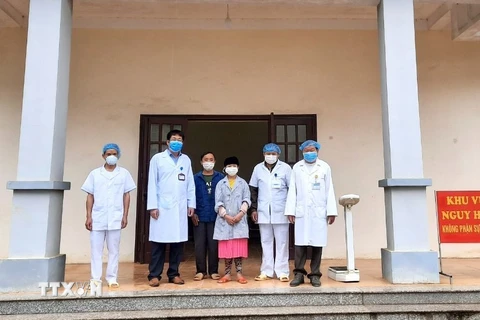 Các y bác sỹ Bệnh viện Đa khoa huyện Đồng Văn (Hà Giang) chụp ảnh với bệnh nhân 268 khi được công bố khỏi bệnh. (Ảnh: TTXVN phát)