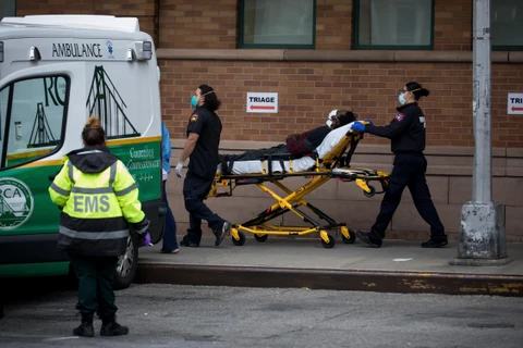 Nhân viên y tế chuyển bệnh nhân COVID-19 tới trung tâm y tế Maimonides, New York, Mỹ hôm 19/4. (Ảnh: THX/TTXVN)