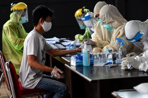 Nhân viên y tế xét nghiệm nhanh COVID-19 cho người dân tại chợ Bumi Serpong Damai ở Nam Tangerang, Banten, Indonesia. (Ảnh: THX/TTXVN)