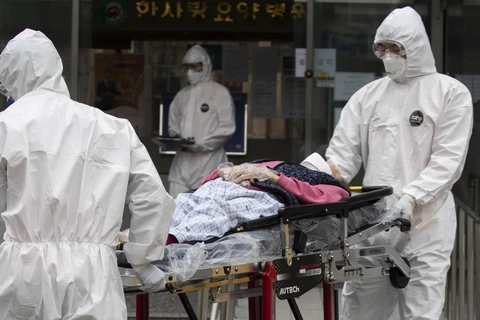 Nhân viên y tế chuyển bệnh nhân COVID-19 tới bệnh viện ở Daegu, Hàn Quốc, ngày 19/3/2020. (Ảnh: THX/TTXVN)