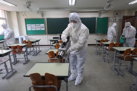 Nhân viên kiểm dịch phun khử trùng một lớp học ở Seoul, Hàn Quốc. (Ảnh: Yonhap/TTXVN)