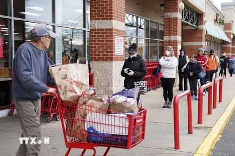 Người dân xếp hàng bên ngoài một siêu thị ở Crossroads thuộc Bailey, Mỹ trong bối cảnh dịch COVID-19 lây lan mạnh. (Ảnh: AP/TTXVN)