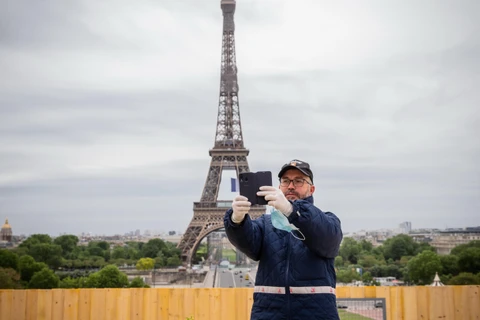 Khách du lịch chụp ảnh lưu niệm trước Tháp Eiffel ở thủ đô Paris, Pháp ngày 11/5/2020. (Ảnh: THX/TTXVN)